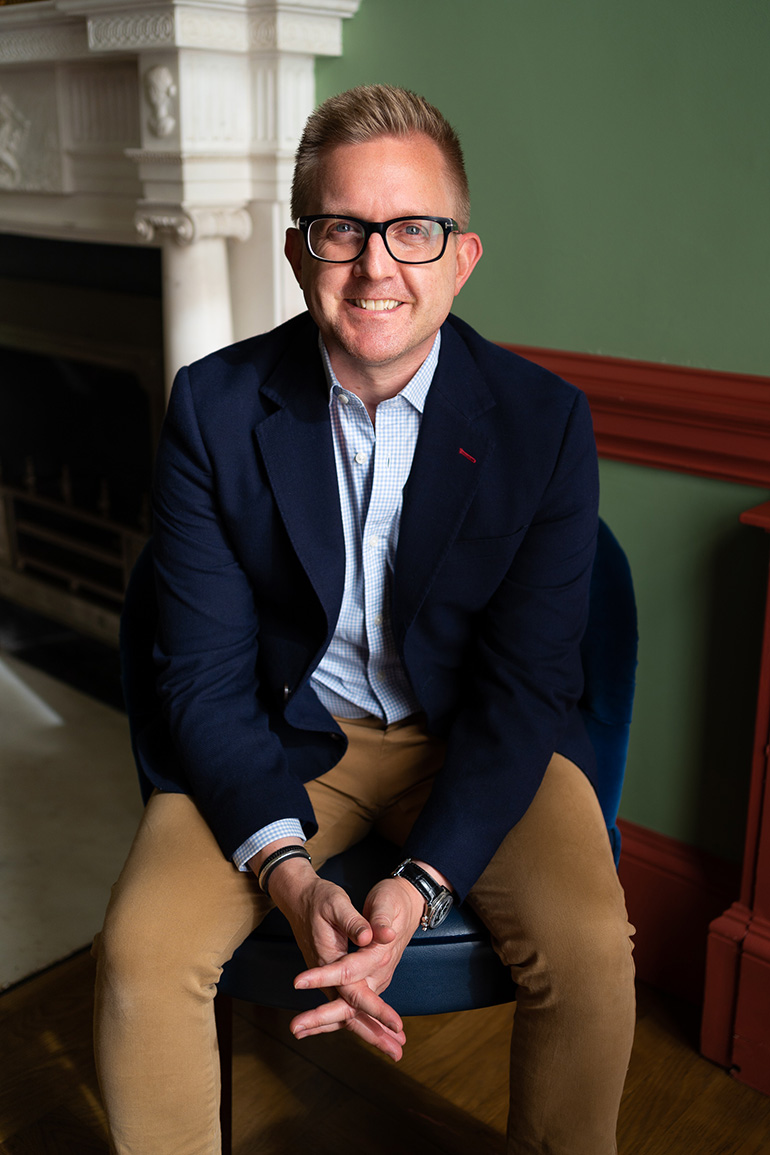 Benjamin Lamping of Reframe Capital smiles at the camera sitting in a chair